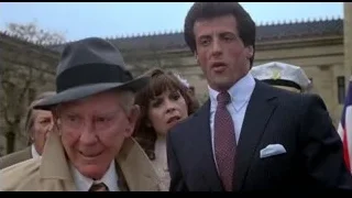 man in trench coat and fedora shouting — Rocky III