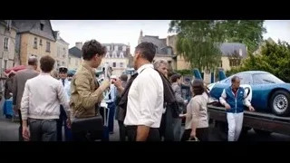 Man holding sign "52" on street — Ford v Ferrari
