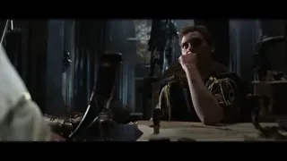 man in robe sitting at cluttered desk — Gladiator