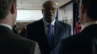 bald man in suit by American flag — Suits