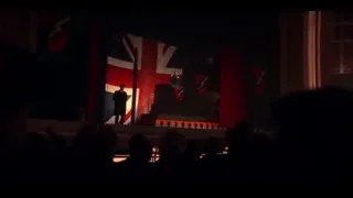 Man giving speech on stage with British flag — Peaky Blinders