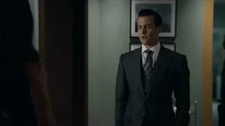 man in suit and woman standing in hallway — Suits