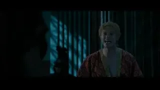 Man in red robe in dimly lit room — Gladiator 2