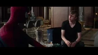 Young man on blue armchair in dim room — The Amazing Spider Man 2