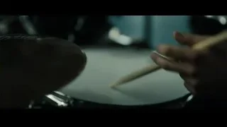 person's hand playing drums with drumstick — Whiplash