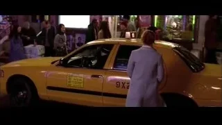 woman standing by yellow taxi on busy street — Spider Man 2