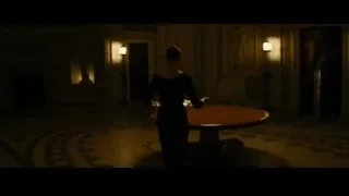 woman in dimly lit room with round table — Batman: The Dark Knight Rises