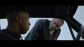 man sitting in car looking out window — Creed 2