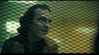 man's face through chain-link fence — Joker