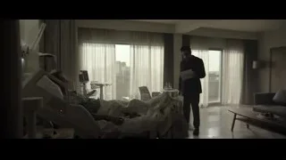 man in suit looking at unconscious patient in hospital — F1