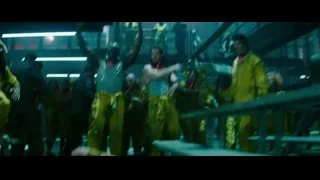 People in yellow jumpsuits in dark room — Deadpool 2