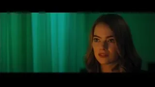 young woman in dimly lit room with green curtain — La La Land
