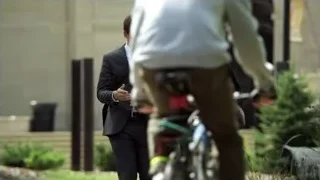 man and woman walking on sidewalk — Suits