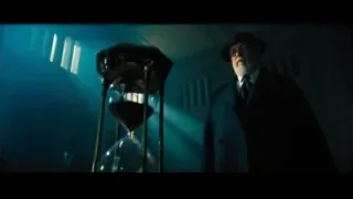 man with hourglass in dimly lit room — John Wick: Chapter 4