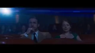 man and woman in dimly lit movie theater — La La Land