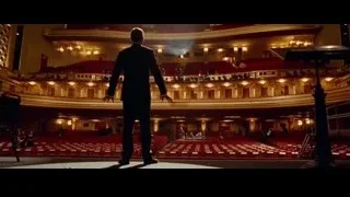 man standing in large auditorium with musicians — Steve Jobs