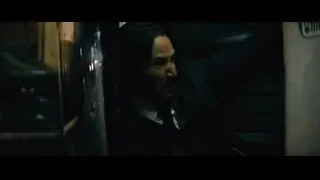 Man crouching on cobblestone street — John Wick: Chapter 4