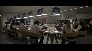 People working in control room with multiple screens — F1