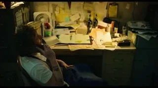 man talking on phone at a dimly lit office desk — The Bear