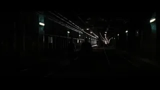 Person walking on train track in dark tunnel — Batman: The Dark Knight Rises