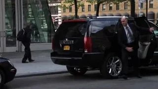 Men in suits walking by black SUV — Suits