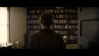 person standing in dimly lit room with bookshelf — Interstellar