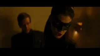 man pointing gun at woman in dimly lit room — Batman: The Dark Knight Rises