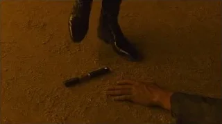 person reaching for flashlight on dirt ground — Blade Runner 2049