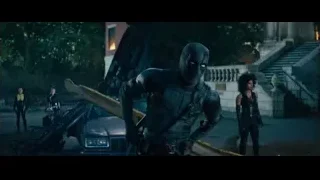 man in black mask holding gun by car — Deadpool 2