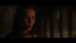 Woman in gold dress in dimly lit stone room — Gladiator