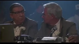 two men in suits talking at table — Rocky III
