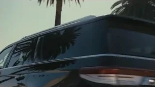 Black SUV driving past palm trees — Succession