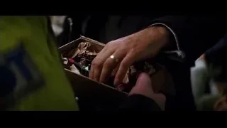 Hand holding small robot-like object — Batman: The Dark Knight