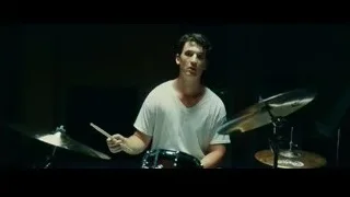 Young man playing drums in dimly lit room — Whiplash