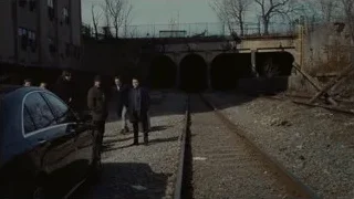 Men in suits walking on railway track — Succession