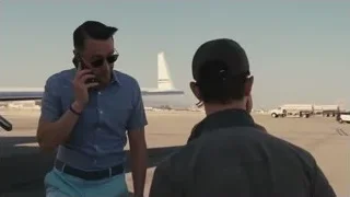 Man walking up airplane stairs on phone — Succession