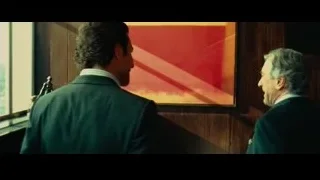 two men conversing in room with painting — Limitless