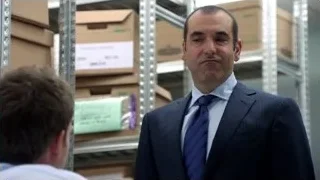 Man in suit speaking to man in warehouse — Suits
