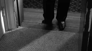 person walking through doorway black and white — Suits
