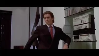 man in suit standing in room with window — American Psycho