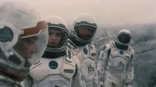 three astronauts on rocky surface — Interstellar