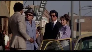 three people on busy street by yellow car — Rocky III