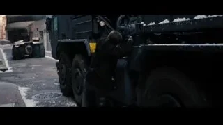 man pushing armored vehicle on snowy street — Batman: The Dark Knight Rises