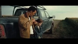 man and woman standing by pickup truck in field — Interstellar