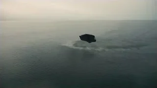 small black boat floating on ocean — Interstellar