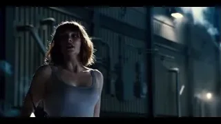 woman standing in a dimly lit industrial space — Jurassic World