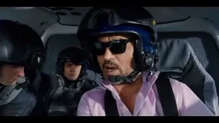 two men in helicopter back seat over mountains — Jurassic World