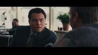 two men in suits talking at office desk — The Wolf Of Wall Street