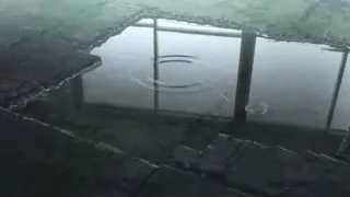 puddle of water reflecting concrete structure — Weathering with You