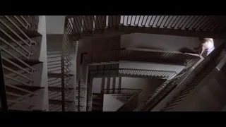 man holding chainsaw near spiral staircase — American Psycho